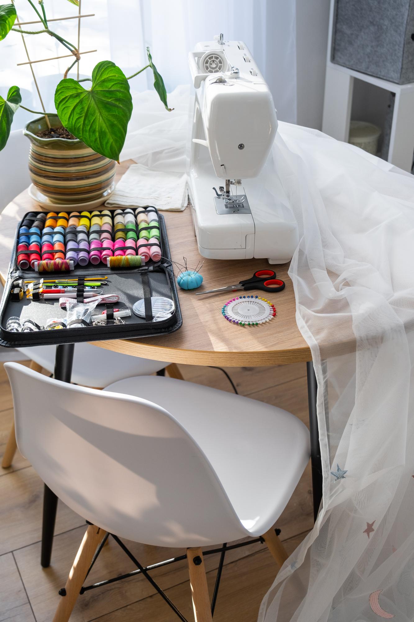Wnętrze atelier z maszyną do haftu i oprawionymi próbnikami